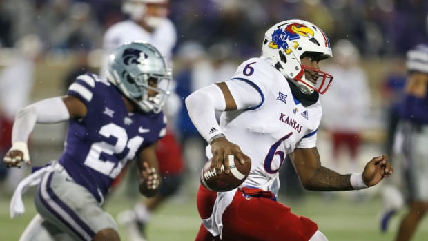Nov 26, 2022; Manhattan, Kansas, USA; Kansas Jayhawks quarterback Jalon Daniels (6) runs away from Kansas State Wildcats safety Drake Cheatum (21) during the fourth quarter at Bill Snyder Family Football Stadium. Mandatory Credit: Scott Sewell-USA TODAY Sports
